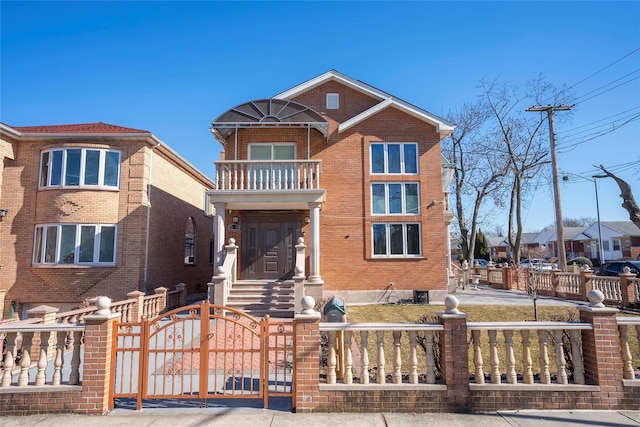 view of front facade with brick siding, a fenced front yard, a gate, and a balcony