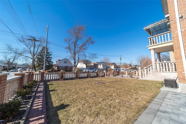 view of yard featuring central air condition unit, a residential view, and fence