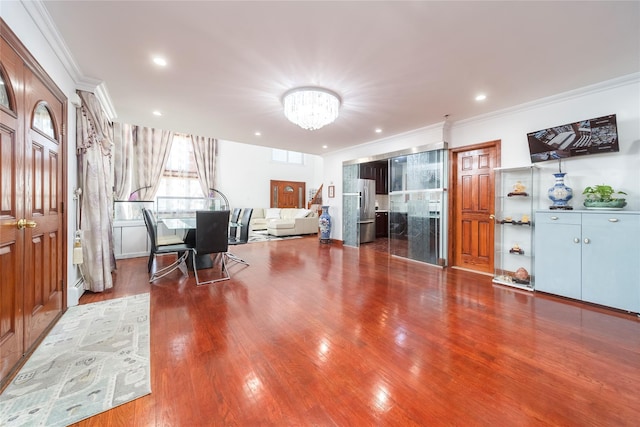 interior space with a notable chandelier, recessed lighting, wood finished floors, and crown molding