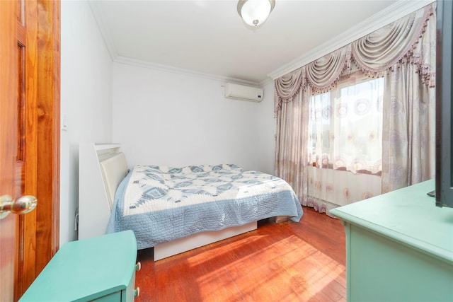 bedroom with an AC wall unit, crown molding, and wood finished floors