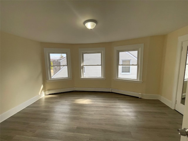 unfurnished room with dark wood-style floors, a baseboard radiator, and baseboards