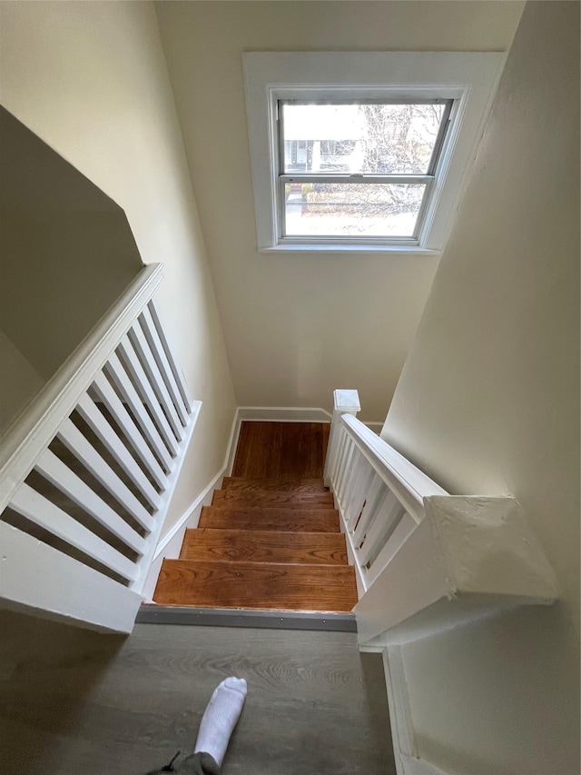 staircase with baseboards and wood finished floors