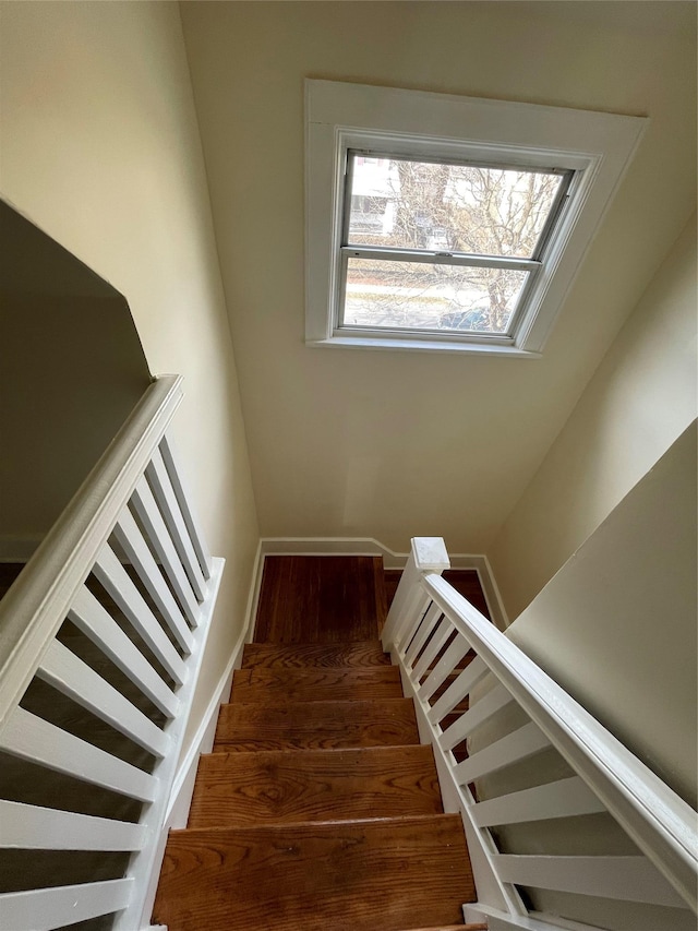 stairway featuring baseboards and wood finished floors