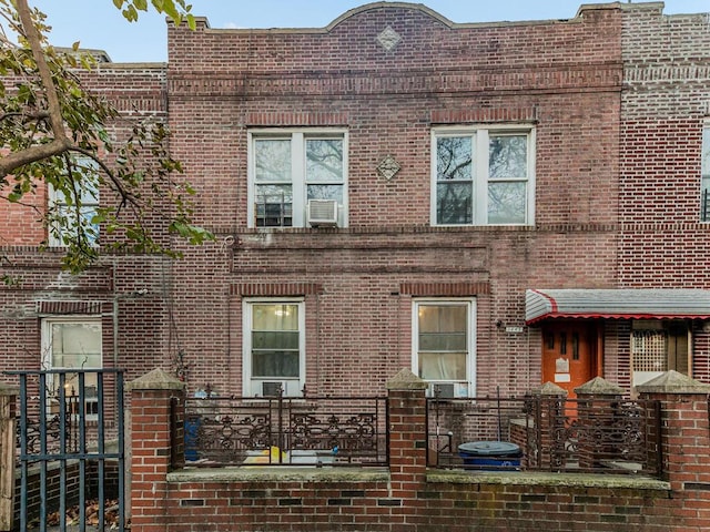 view of property featuring brick siding and fence