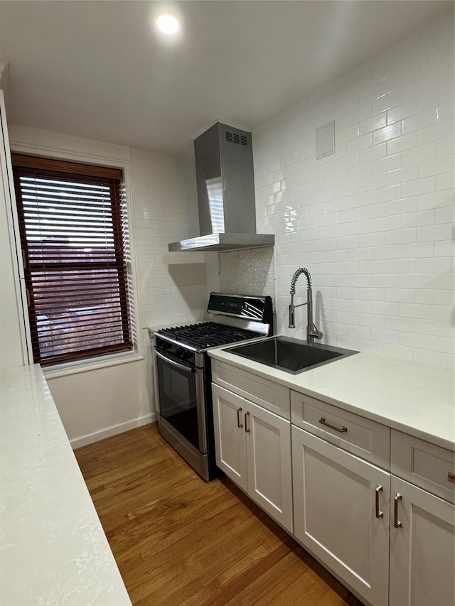 2860 Bailey Ave Unit 7L, Bronx, NY 10463 - kitchen with wall chimney exhaust hood, stainless steel gas range oven, light wood finished floors, decorative backsplash, and light countertops