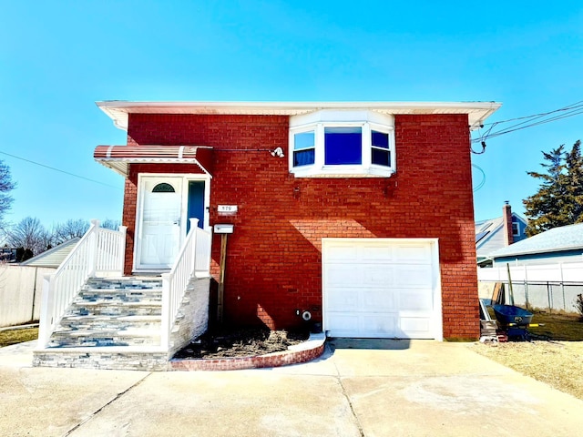 view of front facade featuring concrete driveway, brick siding, an attached garage, and fence