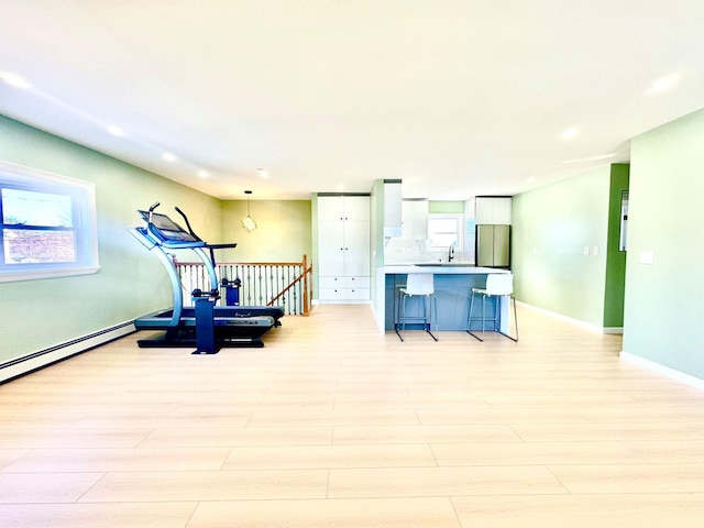 exercise area with light wood-style floors, recessed lighting, and baseboards