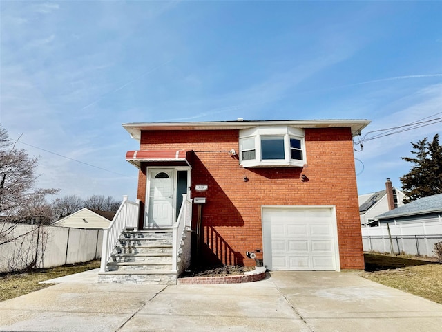 view of front of home featuring concrete driveway, an attached garage, fence, and brick siding