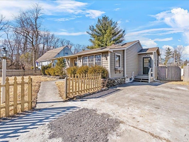 ranch-style home with a fenced front yard and concrete driveway