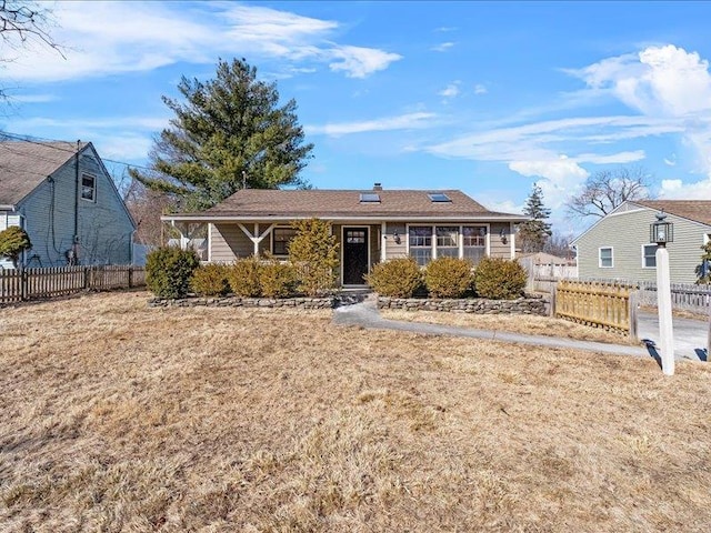 single story home featuring a front lawn and fence