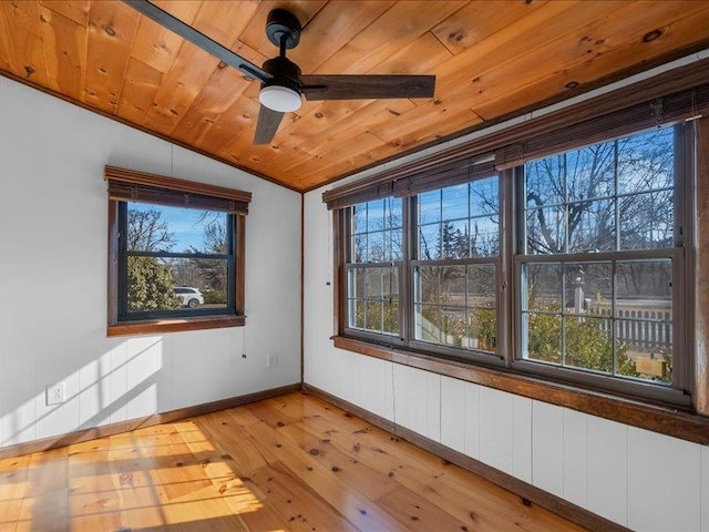 empty room featuring light wood-type flooring, wooden ceiling, baseboards, ceiling fan, and vaulted ceiling