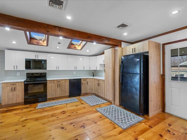 kitchen with visible vents, black appliances, light wood-style flooring, and light countertops