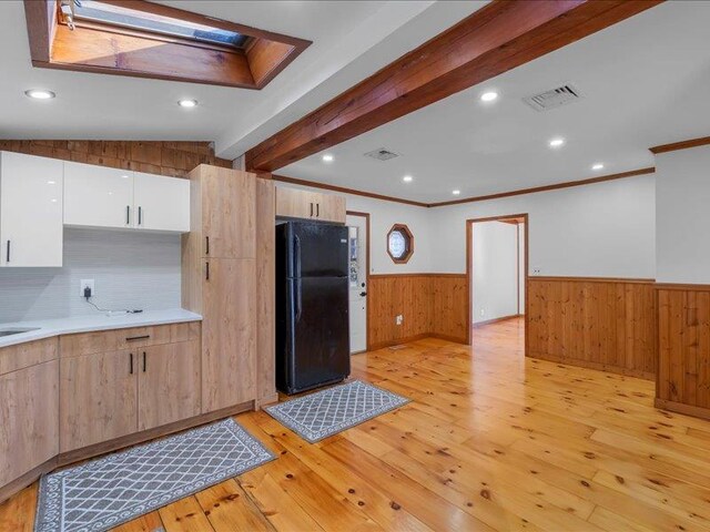 kitchen featuring visible vents, beamed ceiling, light wood-type flooring, wainscoting, and freestanding refrigerator