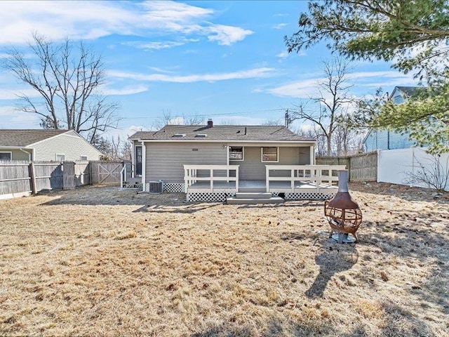 rear view of property featuring a deck and a fenced backyard