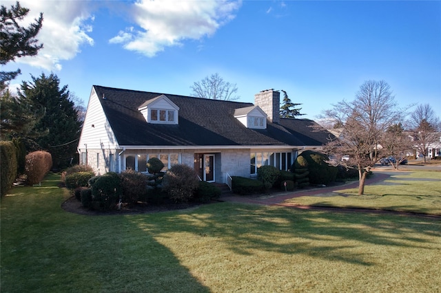 cape cod home featuring a front yard and a chimney