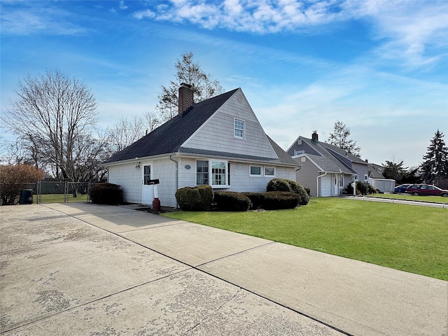 view of front of home featuring a front yard, driveway, a chimney, and fence