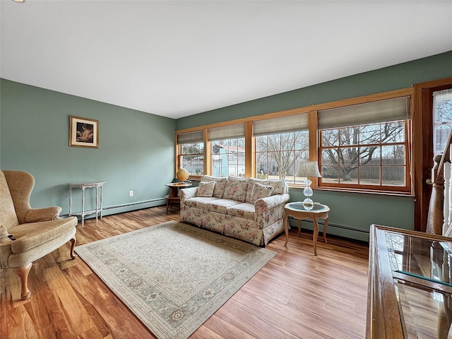 living area featuring a baseboard radiator, wood finished floors, and baseboards