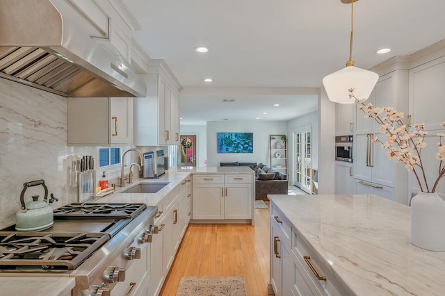 kitchen with light stone counters, extractor fan, light wood-style flooring, open floor plan, and tasteful backsplash