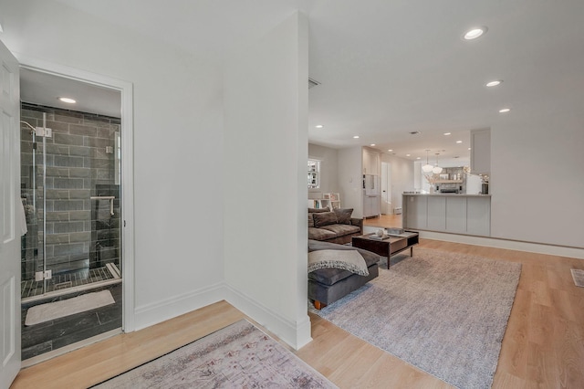 living room with light wood-type flooring, baseboards, and recessed lighting