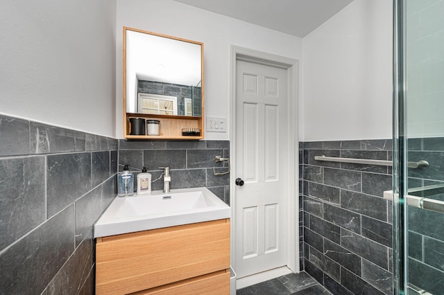 bathroom with wainscoting, tiled shower, tile walls, and vanity