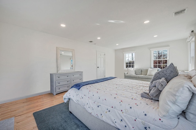 bedroom with light wood finished floors, recessed lighting, visible vents, and baseboards