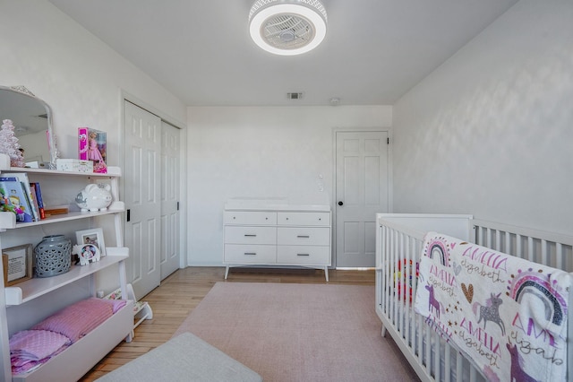 bedroom featuring a closet, visible vents, and wood finished floors