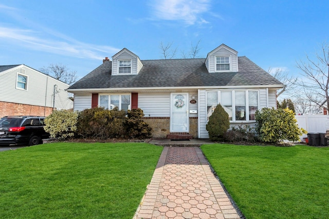 cape cod house with roof with shingles and a front yard