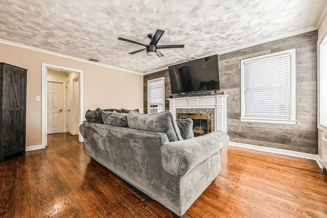 living room featuring a fireplace, wood finished floors, and crown molding