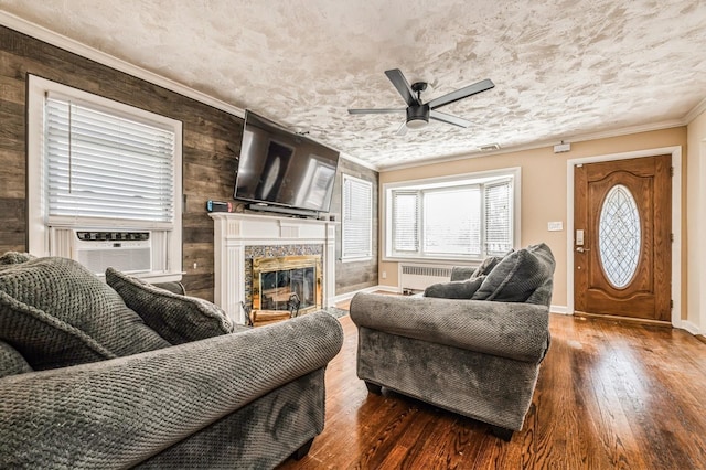 living area with ornamental molding, radiator heating unit, a fireplace, and hardwood / wood-style flooring