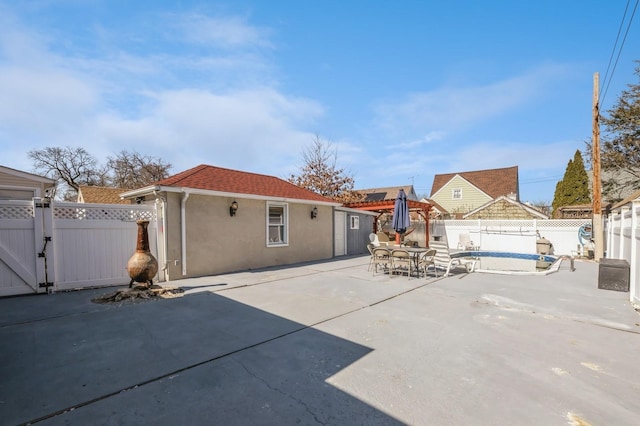 exterior space featuring outdoor dining space, a fenced backyard, a patio, and stucco siding