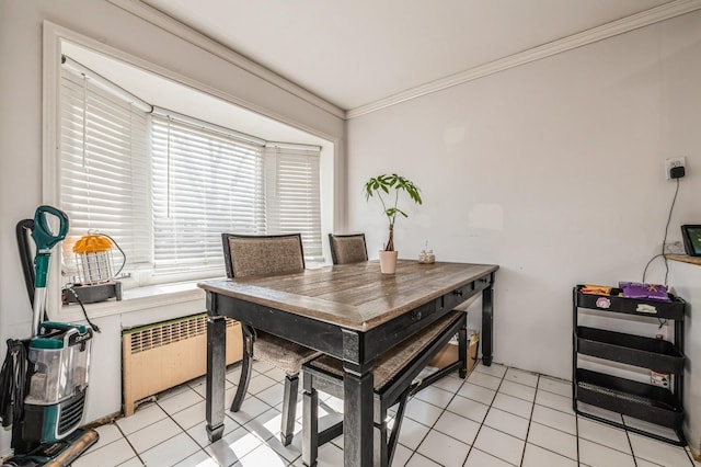 dining area featuring light tile patterned floors, ornamental molding, and radiator