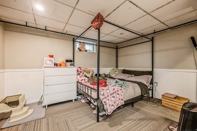 bedroom with wainscoting and a drop ceiling