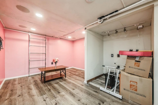 interior space featuring track lighting, baseboards, and wood finished floors