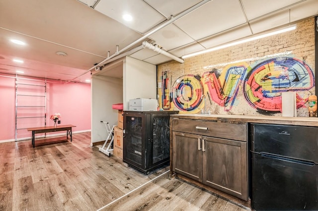 bar featuring brick wall and light wood finished floors