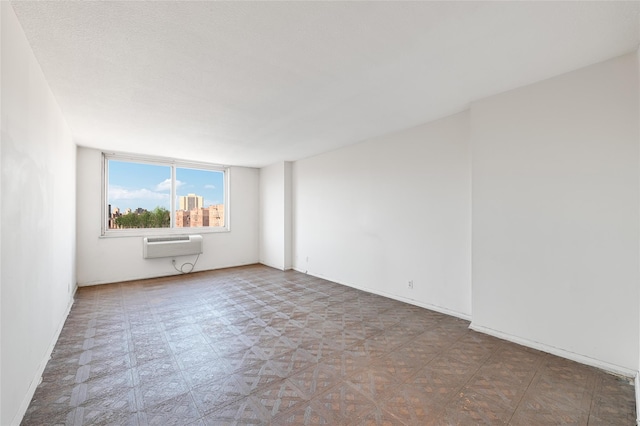 empty room with tile patterned floors and a wall mounted AC