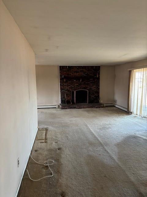 unfurnished living room featuring a baseboard heating unit, a brick fireplace, and carpet