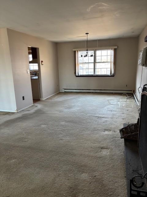 unfurnished living room featuring baseboards, light colored carpet, and baseboard heating