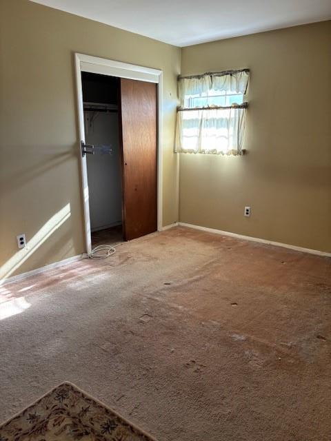 unfurnished bedroom featuring a closet, carpet flooring, and baseboards