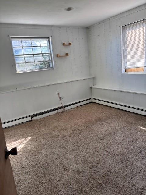 empty room featuring a baseboard radiator and carpet flooring