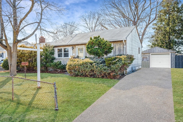 view of front of home with driveway, a garage, fence, an outdoor structure, and a front yard