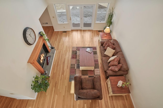 living room featuring visible vents, baseboards, and wood finished floors