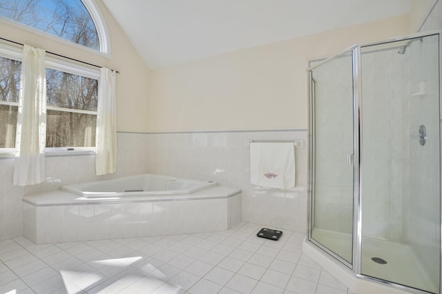 full bathroom featuring lofted ceiling, a stall shower, tile patterned flooring, and a garden tub