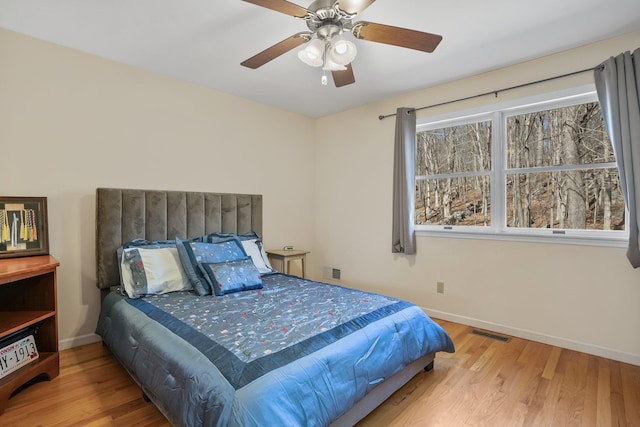 bedroom with visible vents, baseboards, and wood finished floors