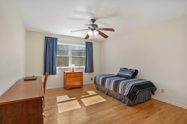 bedroom with light wood-style floors, ceiling fan, and baseboards