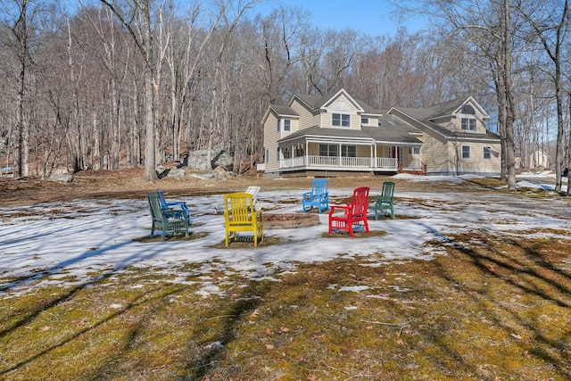 snow covered property with an outdoor fire pit