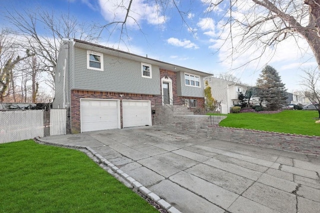 bi-level home with a garage, brick siding, fence, driveway, and a front lawn