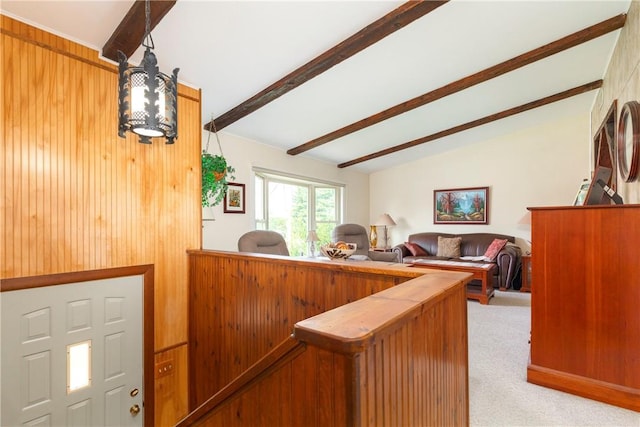 interior space featuring light carpet and lofted ceiling with beams