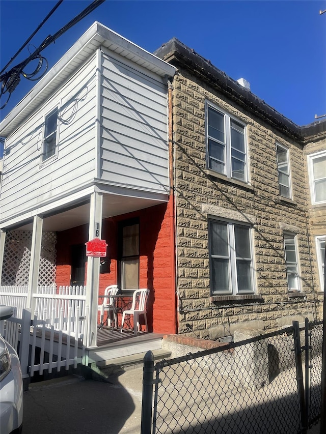 view of side of home with a porch and fence