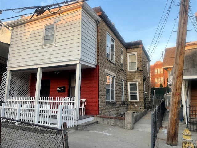 view of front of property featuring fence and a porch