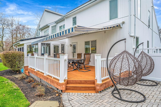 rear view of property featuring a wooden deck and outdoor dining area